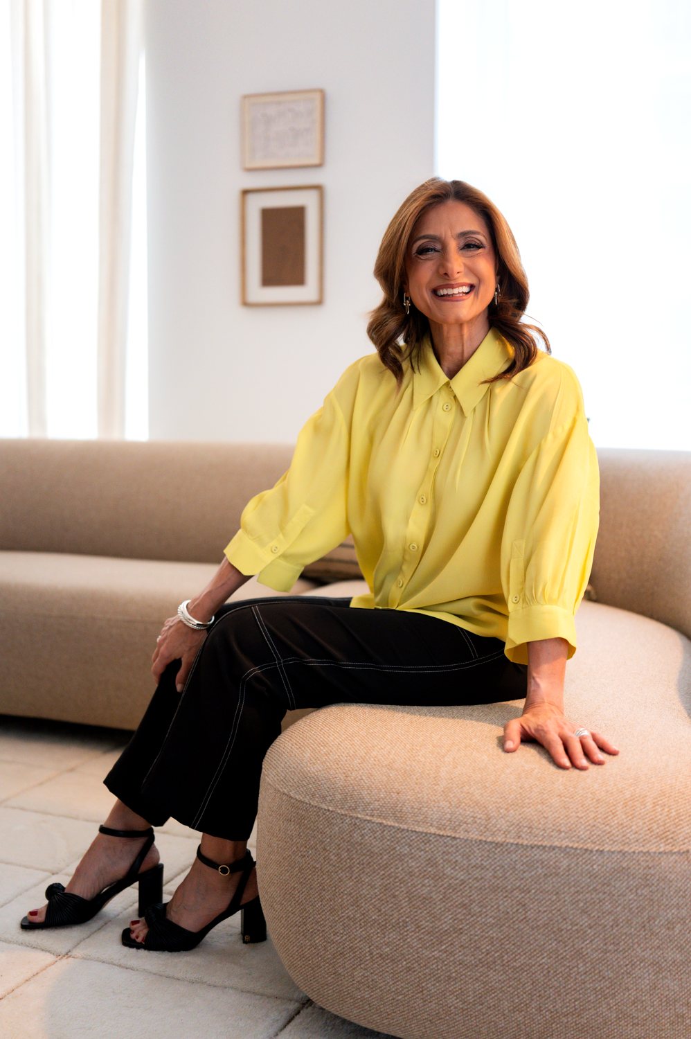 Suzi Dafnis seated in a bright living room, smiling